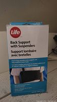 Front of the box showing Life brand back support with suspenders, highlighting dual straps and lumbar support features.