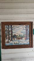 Front view of the framed handpainted winter landscape painting showing the barn, horses, and snowy scene.