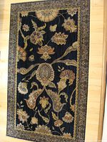 Full view of the antique woven carpet showing overall floral design and border.
