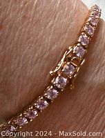 Close-up photo of the bracelet showing the pink round stones and the gold vermeil setting on a wrist, highlighting the shine and clasp area.