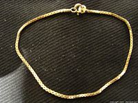 Full view of the gold box chain bracelet laid flat to show length and overall condition.