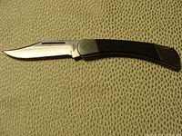 Photo of the full Coast 440 C folding knife with blade open and black handle visible.