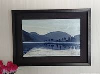 Frontal view of the oil painting showing the scenic lake, mountains, trees, and reflection in water framed in black shadow box.