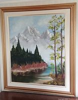 Frontal view of the framed oil painting showing the complete artwork of mountain landscape with trees and river.
