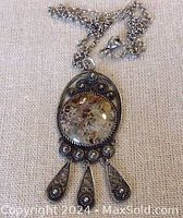 Photo of sterling silver pendant with jasper-like round gemstone and decorative dangling drops along with connected chain with clasp.