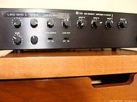 Front panel view of TOA amplifier showing microphone level, volume, bass, tone defeat, low cut controls, and multiple input volume knobs.