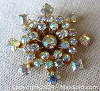Front view showing the star-shaped gold tone brooch with sparkling AB round and square rhinestones.