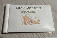 Front cover of white photo album with gold text 'Grandmother's Treasures'.