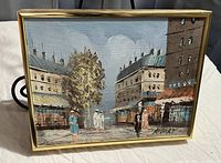 Framed oil painting depicting a street scene with buildings and figures, signed by Robert at bottom right.