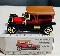 Side profile of the Pierce Arrow model car placed on top of its original box, showing detailed colors and construction.