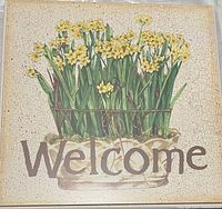 Photo of the square wooden wall sign with painted yellow flowers and the word 'Welcome' on the front, showing the crackled finish and vintage look.