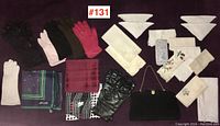 Photo showing entire assortment of items including gloves, scarves, handkerchiefs, napkins, and purse all laid out on a purple surface with lot number #131 visible.