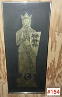 Framed brass rubbing showing a knight wearing a crown, praying, holding a shield with three lions, with a figure beneath the feet.