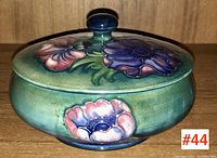 Side view of the Moorcroft lidded box showing colorful flowers and knob handle on lid.
