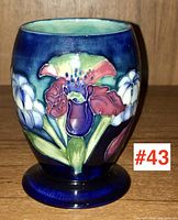 Front view of Moorcroft vase showing red, white, and purple flowers on a deep blue background.