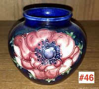 Front view of the Moorcroft vase showing detailed floral design and dark blue glaze.