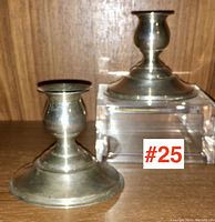 Pair of International sterling silver candlesticks displayed on a wooden surface with a clear acrylic riser, showing size and shape.