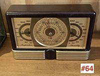 Front view of brown Bakelite housing with central barometer and side thermometer and hygrometer dials