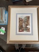 Framed watercolour artwork of a Quebec street scene, showing overall presentation and condition.