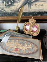 Overall display showing both Canadian Millennium coin sets in folders, decorative royal coin frame with Princess Diana and Queen Elizabeth coins, and gold feather pen inkwell.