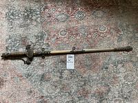 Full-length photograph of sword and scabbard laid on patterned rug