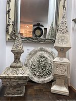 Full view of the two pierced tin lanterns with plaster cherub medallion placed behind them, showing scale and overall appearance.