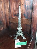Full view of silver-tone Eiffel Tower-shaped stand on wood background