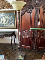 Full view of tall floor lamp standing next to vintage furniture, showing full height and base.