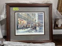 Overall view of framed print wrapped in bubble wrap against wall