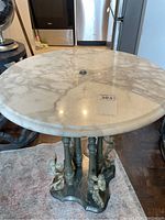 Top view of round marble tabletop showing natural veining and minor surface reflections.