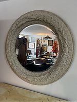 Full front view of round mirror hanging on wall