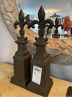 Front view of both finials on table with mirror reflection