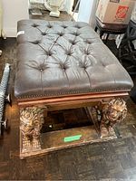 Front view of complete seat assembly showing tufted cushion and lion-legged base