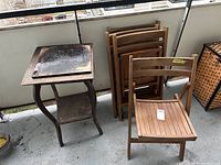 All 4 wooden folding chairs stacked folded, one unfolded, and Project Fern wooden side table with curved legs and lower shelf, showing wear on top