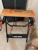 Full view of Black & Decker Workmate showing wooden clamping surface with branding and black metal frame with logo.