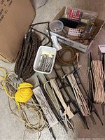 Full view of miscellaneous ropes, pulleys, hardware, and mounting screws in trays and bundles on the floor.