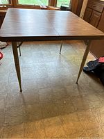 Front view of the vintage kitchen table showing textured pecan Formica top and metal legs.