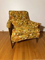 Front view of floral upholstered arm chair showing seat cushion and wooden legs