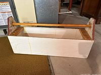 Top and front angle showing the wooden tool box carrier with white paint and wooden handle.