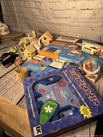Photo shows multiple wooden bird houses, Fiskars crafting tools with packaging, crafting stamps and various crafting supplies arranged on a rustic wooden table.