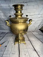 Front view of the antique solid brass samovar showing spigot and base detail.