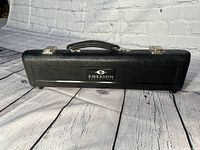 Closed black hard case with Emerson logo and handle on top, placed on a wooden surface.