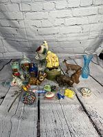 Full view of the lot showing all items including music box, ceramic figurines, glass paperweight, and copper buffalo