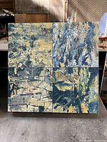 Four-section abstract painting with textured blue, yellow, white tones in mixed media