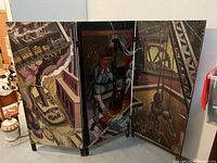 Front view of the three-panel folding screen with industrial paintings