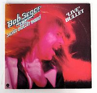 Front cover of the double vinyl album showing Bob Seger in red lighting with band and album title text