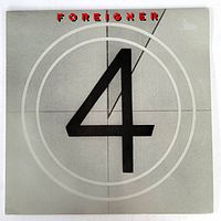 Front view of the vinyl album sleeve showing "Foreigner" written in red at the top, and a large black "4" centered on a grey background with white concentric circles.