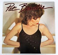 Front cover of the Pat Benatar 'Crimes of Passion' LP showing Pat Benatar wearing a black top with small studs, looking down and to the side, with the album title and name in red cursive text.