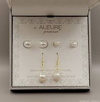Three pairs of sterling silver pearl earrings displayed in branded white box from ALEURE with cover partly open, showing all earrings pinned on holder card inside box.