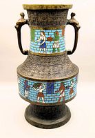 Front and side angled view of bronze vase with cloisonné enamel depicting figures. Includes dragon handles and geometric bronze patterning.